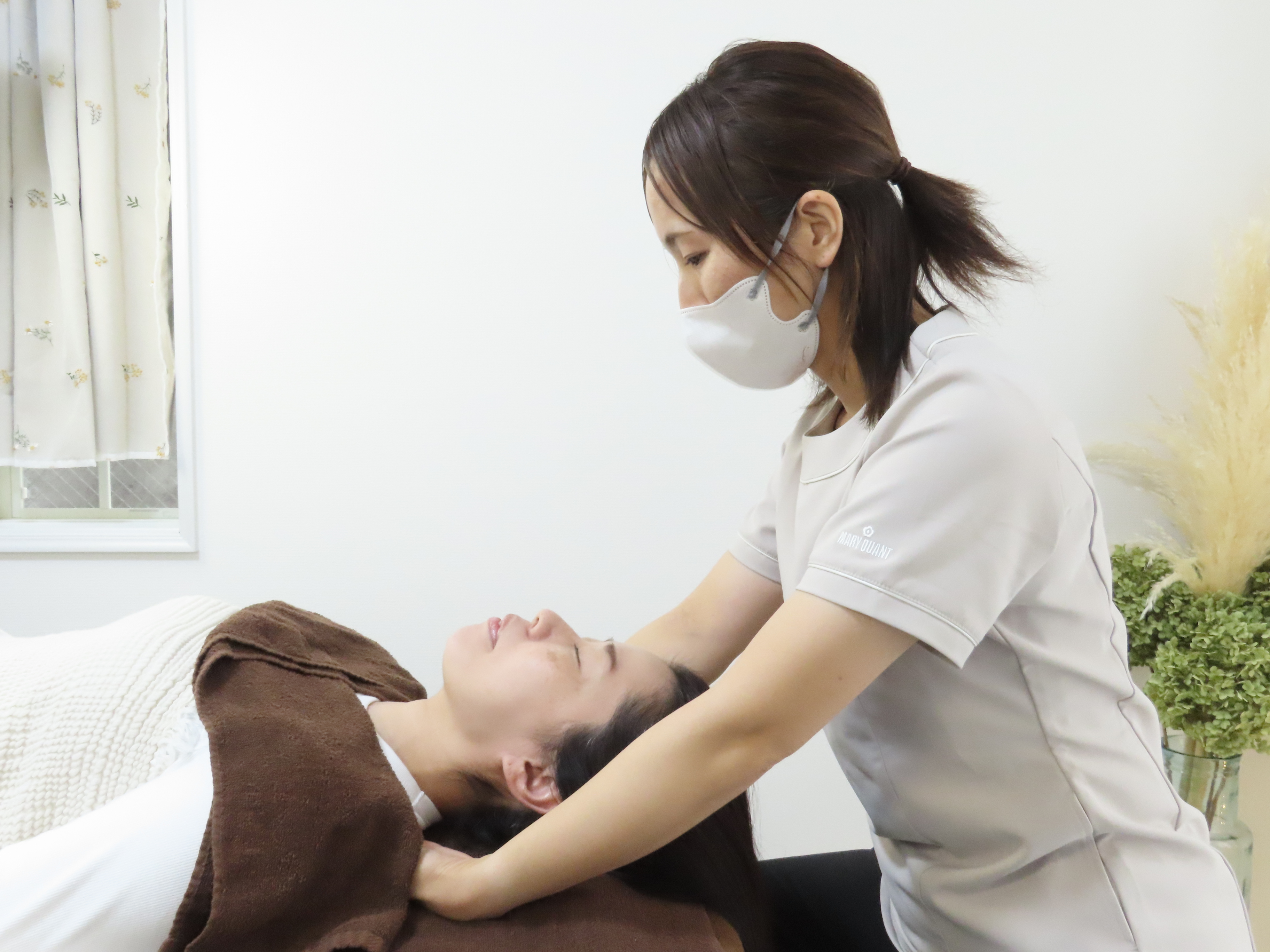 ドライヘッドスパで首元をやさしく支えながら施術する様子